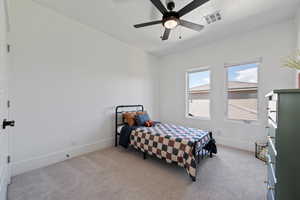 Bedroom featuring light colored carpet, baseboards, and a ceiling fan