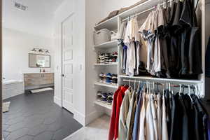 Walk in closet with dark tile patterned flooring