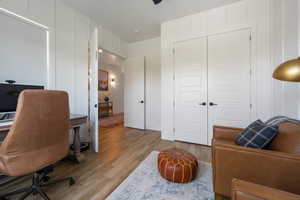 Office space with wood finished floors and a decorative wall