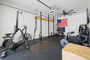 Workout area with a garage and a textured ceiling
