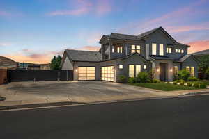 View of front of home with a gate, concrete driveway, stucco siding, and an attached garage