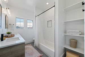 Full bathroom with double vanity, toilet, and shower / bath combination with curtain