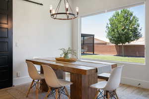 Dining area with a chandelier, baseboards, plenty of natural light, and wood finished floors