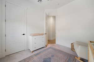 Bedroom featuring light colored carpet and baseboards