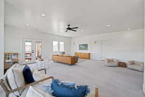 Carpeted living area with french doors, recessed lighting, and a ceiling fan