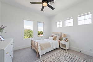 Bedroom with light colored carpet, baseboards, and a ceiling fan
