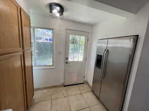 Doorway to outside featuring plenty of natural light and baseboards