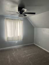 Additional living space featuring a ceiling fan, lofted ceiling, carpet flooring, and baseboards