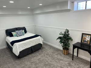 Carpeted master bedroom featuring wainscoting and recessed lighting