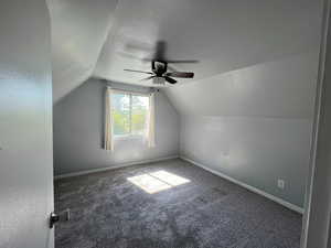 Bonus room featuring a ceiling fan, vaulted ceiling, carpet flooring, and baseboards