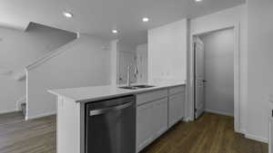 Kitchen with stainless steel dishwasher, a sink, dark wood-style flooring, a peninsula, and recessed lighting