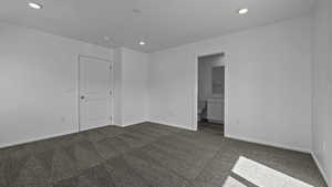 Unfurnished room with dark carpet, recessed lighting, and baseboards
