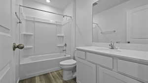 Full bath featuring vanity, wood finished floors, toilet, shower / washtub combination, and recessed lighting