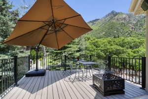 Wooden deck with a mountain view and outdoor dining space