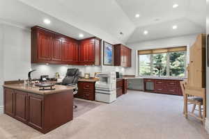 Office area featuring light carpet, built in desk, recessed lighting, and lofted ceiling