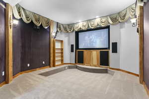 Carpeted cinema room with baseboards and recessed lighting