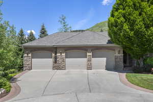 French country style house featuring stone siding, stucco siding, a garage, driveway, and a shingled roof