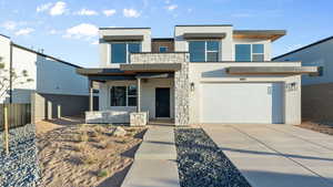 Contemporary house featuring driveway, stucco siding, and an attached garage