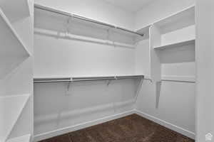 Walk in closet featuring dark carpet