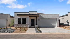 Modern home with a garage, stucco siding, and concrete driveway