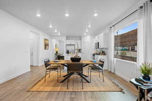 Dining area with light wood finished floors, baseboards, and recessed lighting