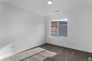 Empty room featuring carpet flooring and baseboards