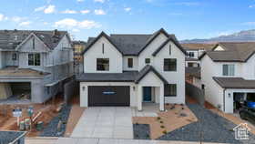 View of front of home featuring driveway, an attached garage, a residential view, and a mountain view