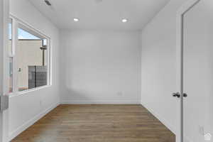 Spare room featuring recessed lighting, baseboards, and wood finished floors