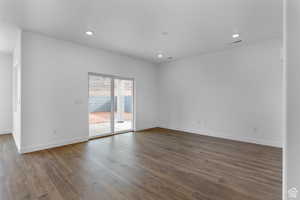 Empty room featuring dark wood finished floors, recessed lighting, and baseboards