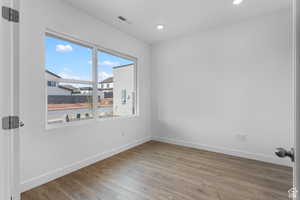 Spare room featuring baseboards, wood finished floors, and recessed lighting