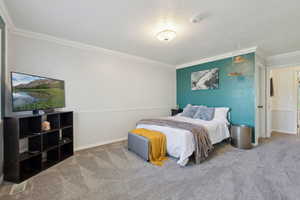 Bedroom featuring crown molding, carpet floors, and baseboards