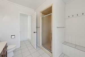 Bathroom with vanity, a shower stall, tile patterned flooring, and toilet