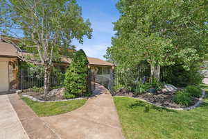 View of property hidden behind natural elements featuring stone siding