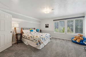 Carpeted bedroom with baseboards and crown molding