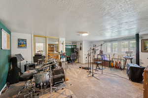Playroom featuring carpet flooring, a textured ceiling, and a desk