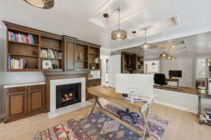 Home office with light wood-type flooring and a fireplace