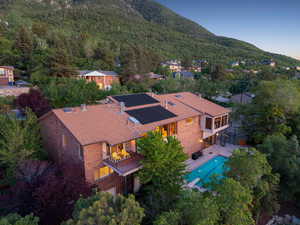View of subject property featuring a mountainous background, a forest, and a pool area