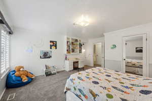 Carpeted bedroom featuring crown molding and baseboards