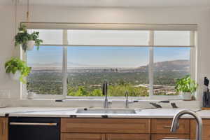 Kitchen with black dishwasher, a sink, a mountain view, and healthy amount of natural light