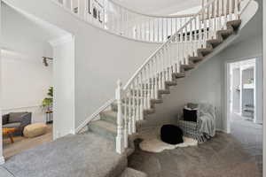 Stairway with carpet floors, ornamental molding, and baseboards