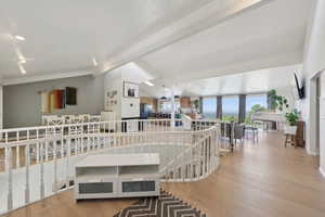 Hall with an upstairs landing, crown molding, and wood finished floors