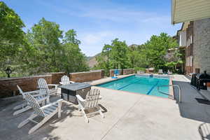 View of pool with a fire pit, a patio area, and a mountain view