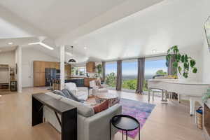 Living room featuring light wood-style flooring, vaulted ceiling, and recessed lighting