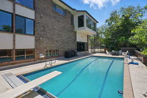 View of pool featuring a diving board and a patio