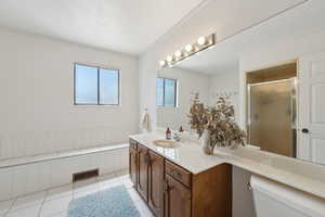 Full bathroom with toilet, vanity, a shower stall, and tile patterned flooring