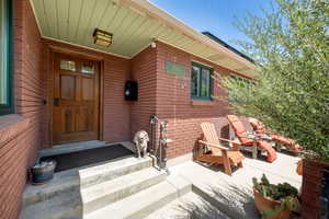 Doorway to property featuring brick siding