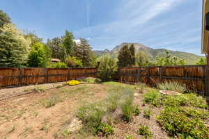 Fenced back-side yard featuring a mountain view