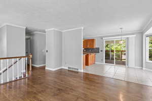 Unfurnished living room featuring light wood-style flooring, baseboards, and ornamental molding