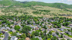 Aerial overview of property's location with a mountainous background and nearby suburban area