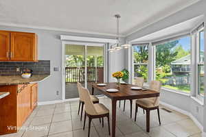 virtually staged Dining room featuring ornamental molding, baseboards, and light tile patterned floors
